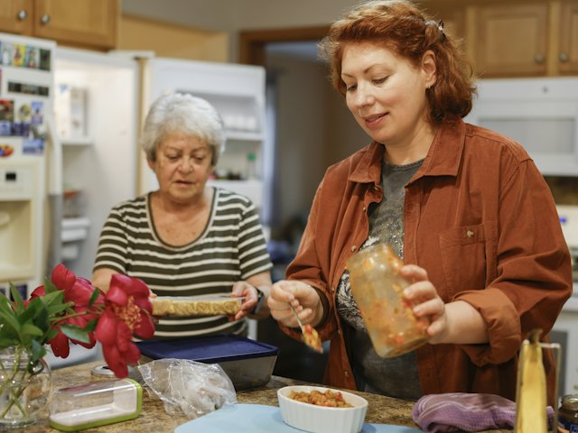 Deux femmes préparent un repas dans une cuisine