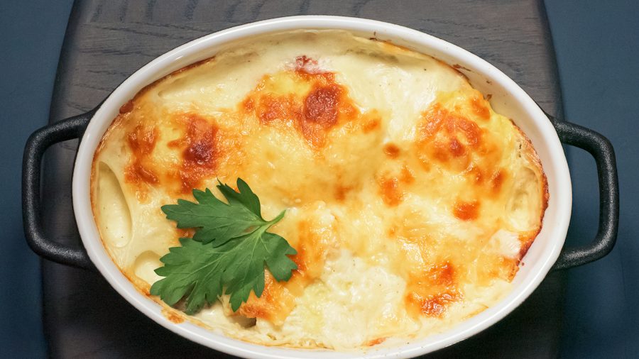 Un gratin au fromage et au persil dans un plat ovale